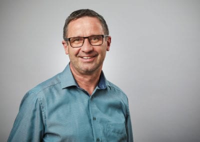 Professionelles Businessportrait eines Mitarbeiters vor neutralem Hintergrund