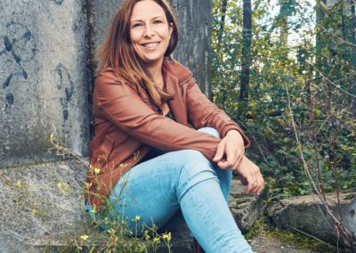 Frau in brauner Jacke bei einem natürlichen Portraitshooting in urbaner Umgebung