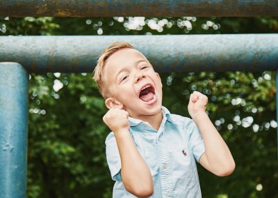 Lachender Junge bei einem natürlichen Kinder-Fotoshooting im Freien