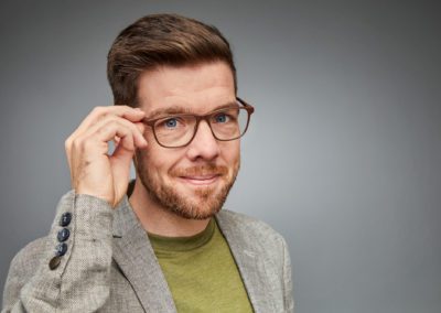 Professionelles Businessportrait eines Mitarbeiters vor neutralem Hintergrund