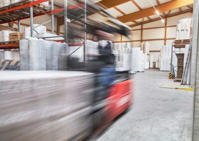 Gabelstapler in Bewegung in einer Lagerhalle mit Vliesrollen