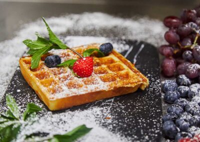 Frisch zubereitete Waffel mit Beeren und Puderzucker