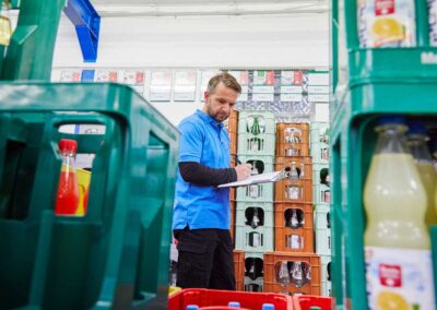 Mitarbeiter bei der Arbeit in einem Verkaufsbereich mit Getränken und Produkten