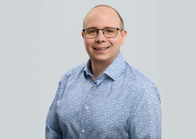 Professionelles Businessportrait eines Mitarbeiters vor hellem Hintergrund