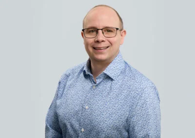 Professionelles Businessportrait eines Mitarbeiters vor hellem Hintergrund