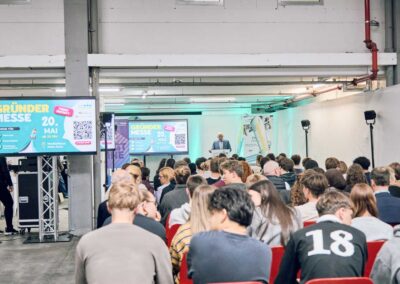 Publikum bei einer Unternehmensveranstaltung mit Präsentation und Bühne